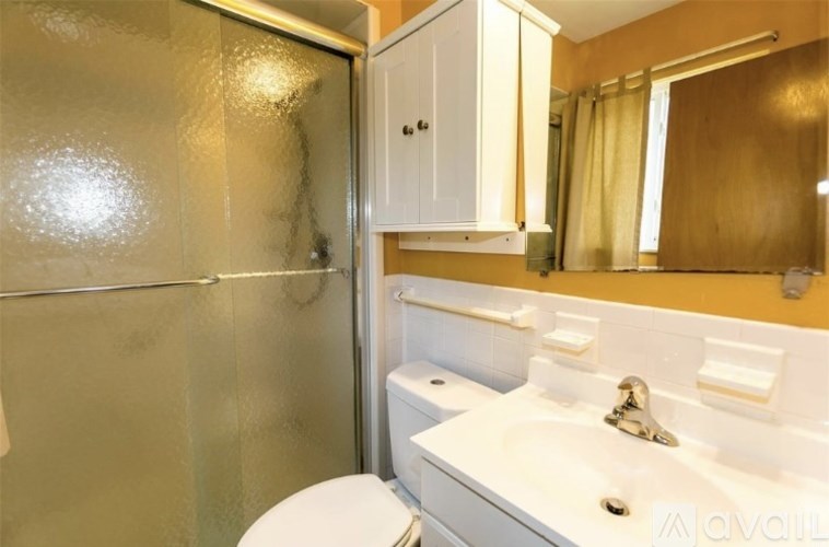 A bathroom with a toilet, sink, and shower.