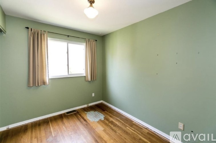 A room with a window and curtains.