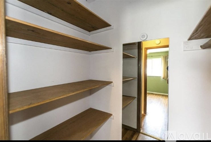 A room with a white wall and a doorway leading to another room.