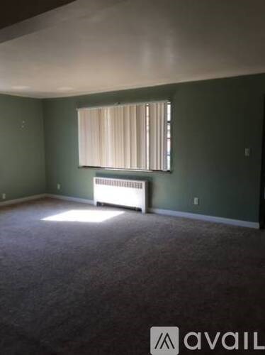 A room with green walls and a window with a white curtain.