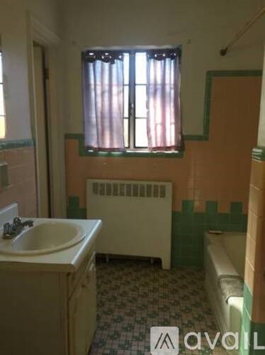 A bathroom with a green wall and a window.