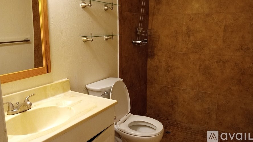 A bathroom with a toilet, sink, and tiled walls.