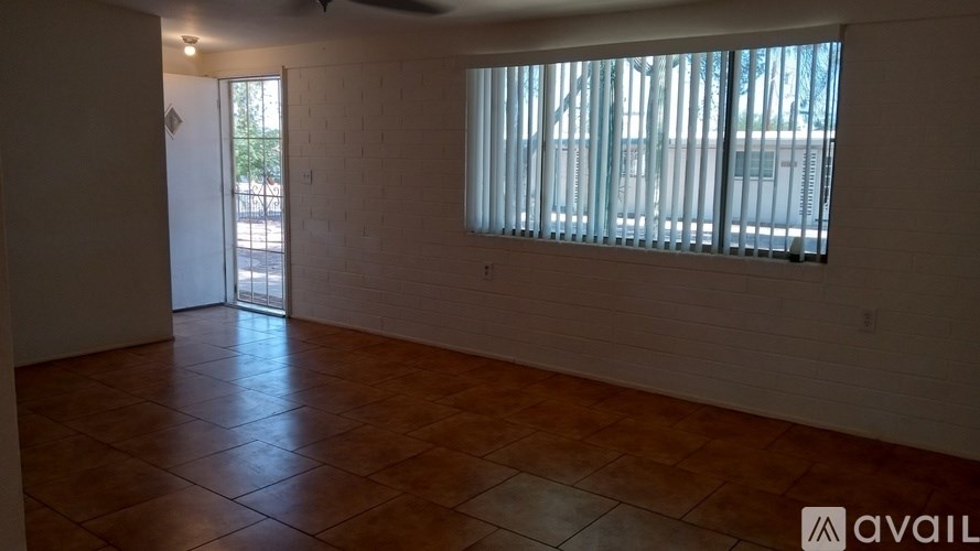 A room with a tiled floor and a window with blinds.