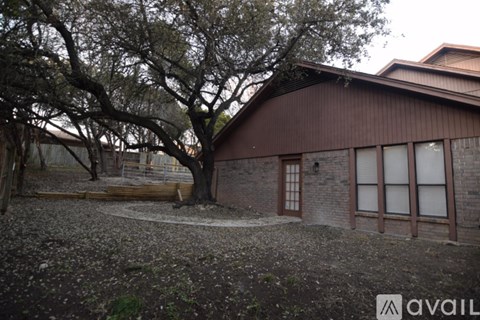 A brown building with a tree in front of it.