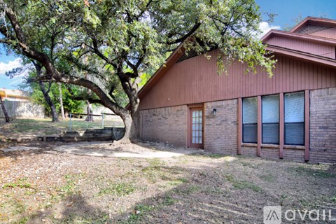 A tree is in front of a small building.
