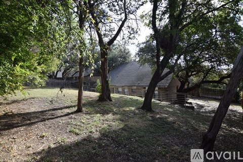 A backyard with trees and a fence.