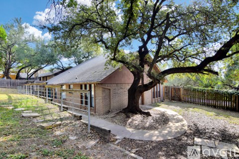 A barn sits in a field with trees in the background.