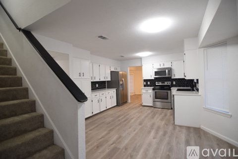A kitchen with a staircase leading to the upper floor.
