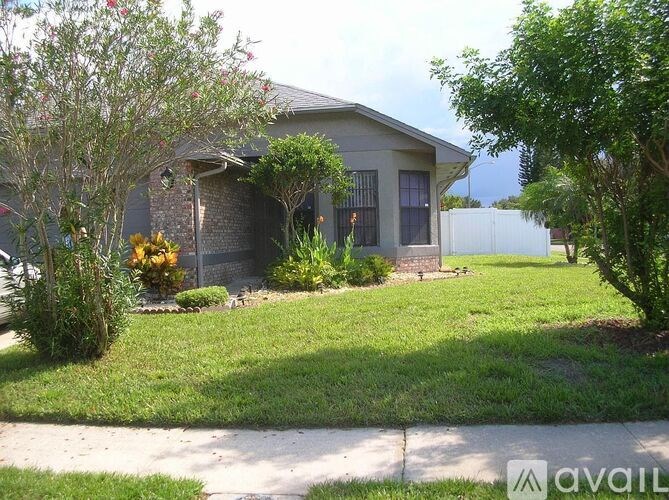 A house with a white picket fence and a green lawn.