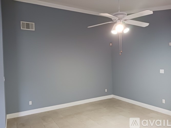 A room with a ceiling fan and light fixture.