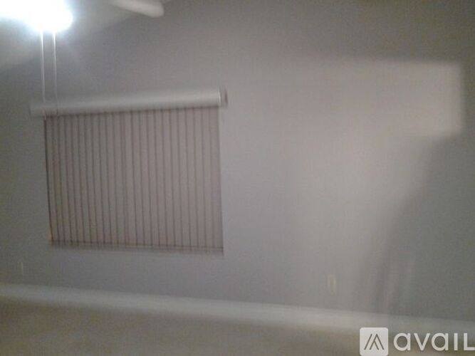 A room with a window covered by a blind.