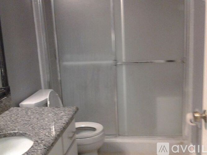 A bathroom with a toilet, sink, and shower.