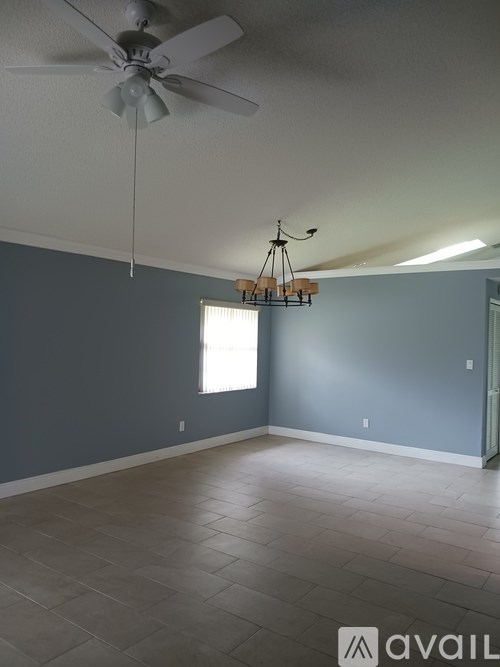 A room with a ceiling fan and a chandelier.