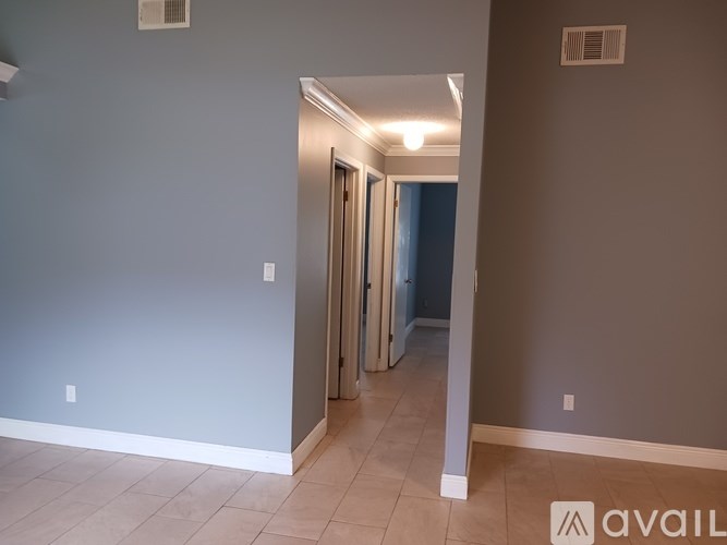 A hallway with a door on the left and a wall on the right.