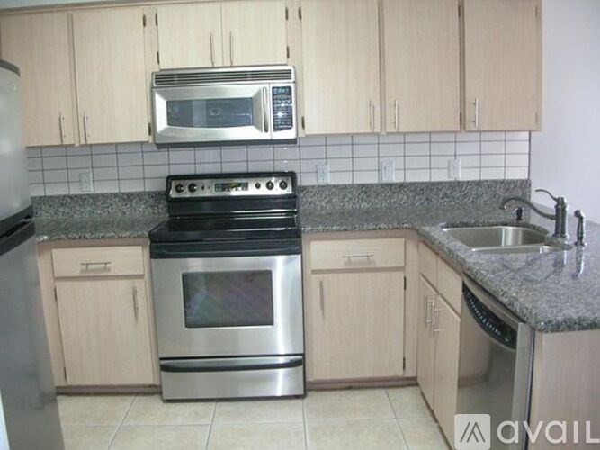 A kitchen with wooden cabinets and a stove top oven.