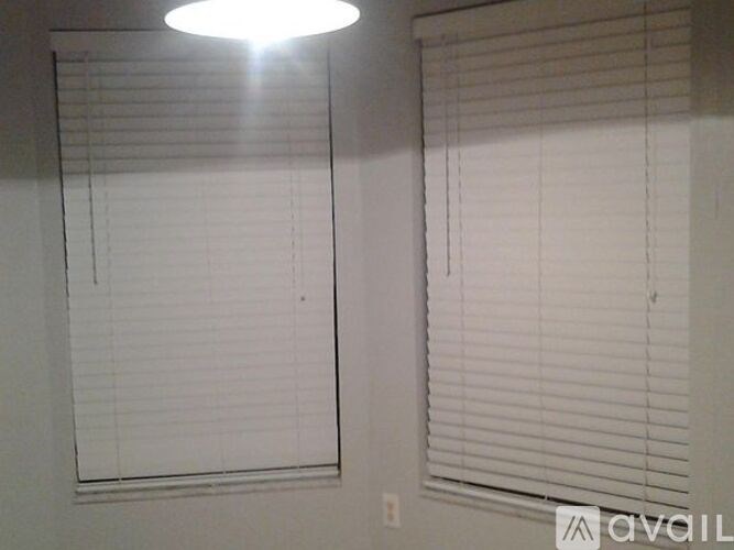 Two windows with blinds in a room.