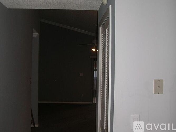 A white door with a silver handle is open.