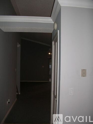 A dark hallway with a light on the wall.