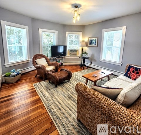 A living room with a brown wicker chair and a brown wicker sofa.