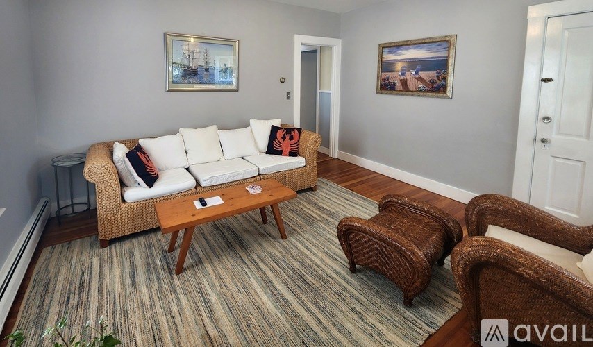 A living room with a white couch, a brown chair, and a wooden coffee table.