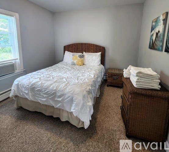 A bedroom with a large bed and a brown headboard.