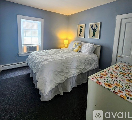 A bedroom with a bed, nightstand, and two wall lamps.