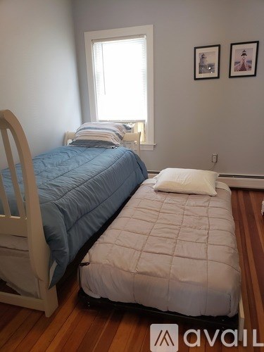 A bedroom with a bed and a chair.