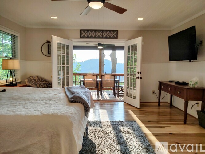 A bedroom with a large bed and a television on the wall.