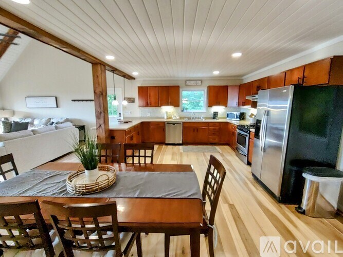 A kitchen with wooden floors and a dining table set for four.