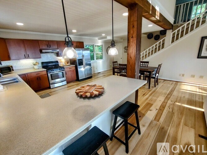A kitchen with a white countertop and wooden flooring.