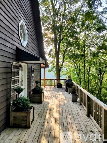 A wooden deck with a person sitting on a chair.