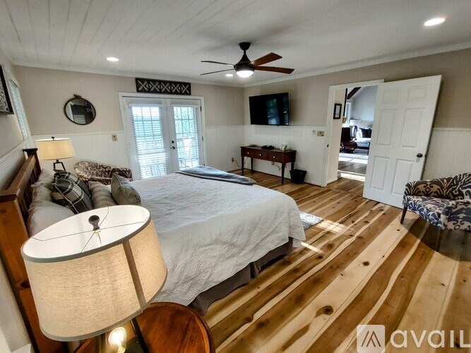 A bedroom with a large bed and a ceiling fan.