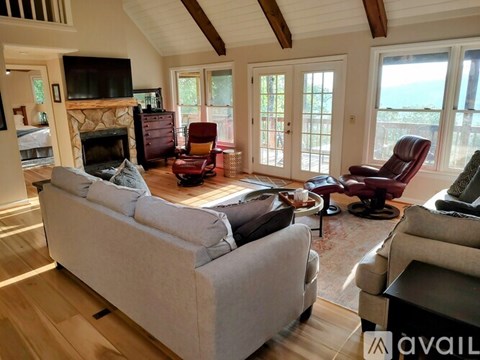 A living room with a grey couch and a fireplace.