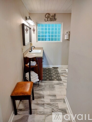 A bathroom with a sink, mirror, and a window.