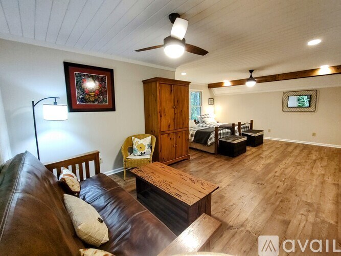 A living room with a brown leather couch and a wooden coffee table.
