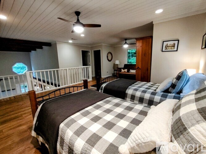 A bedroom with a bed, a ceiling fan, and a window with a view of the ocean.