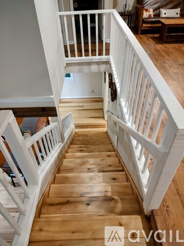 A wooden staircase with white railings.