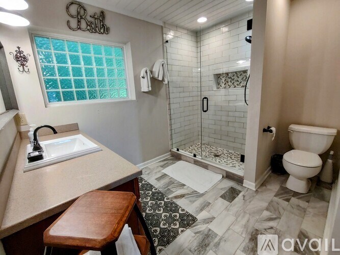 A bathroom with a sink, toilet, and shower.