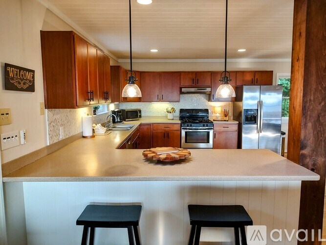 A kitchen with a countertop and bar stools.