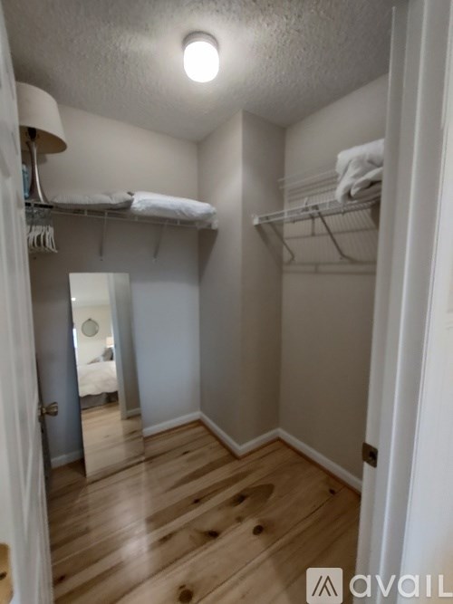 A bedroom with a closet and a mirror.