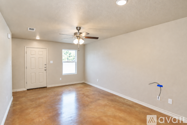 A spacious room with a ceiling fan and a window.
