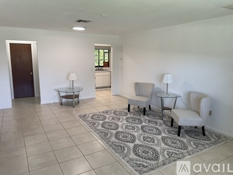 A room with a rug on the floor and a doorway leading to another room.