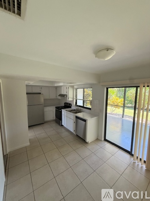 A modern kitchen with white cabinets and a black stove top.