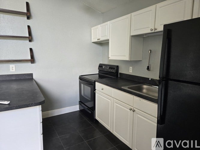 A white refrigerator with a light switch on the wall.