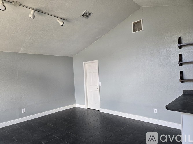A room with a black tile floor and white walls.