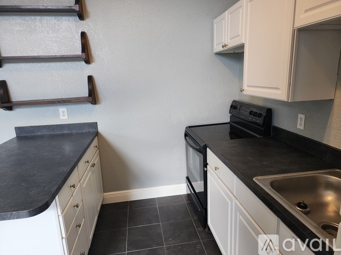 A kitchen with black countertops and white cabinets.