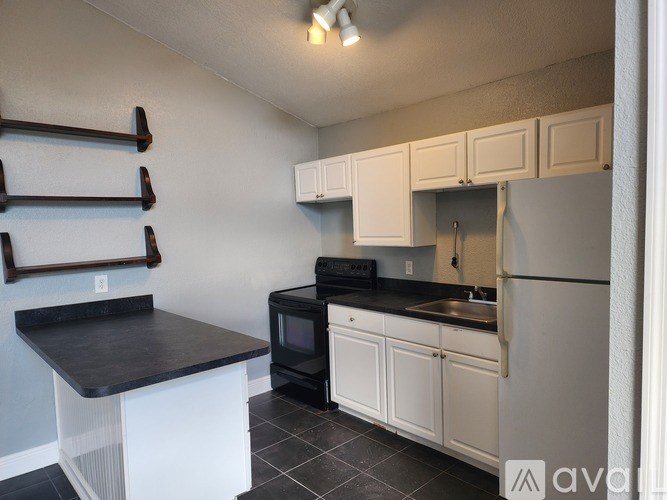 A kitchen with black countertops and white cabinets.
