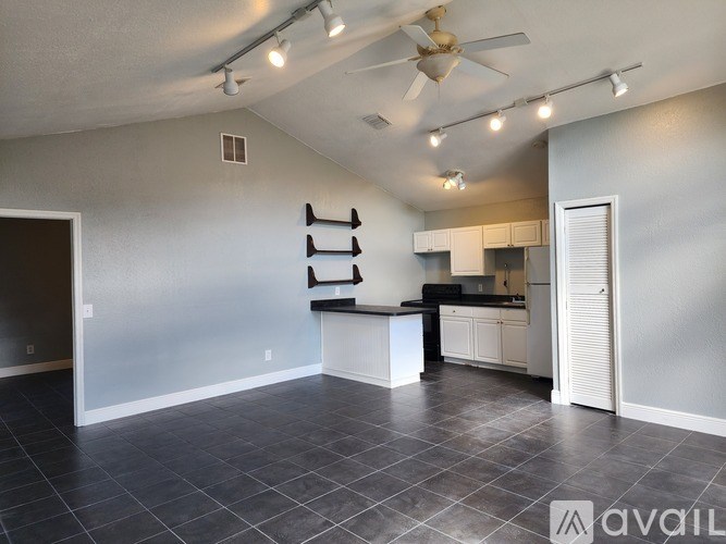 A spacious kitchen with a bar area and a ceiling fan.
