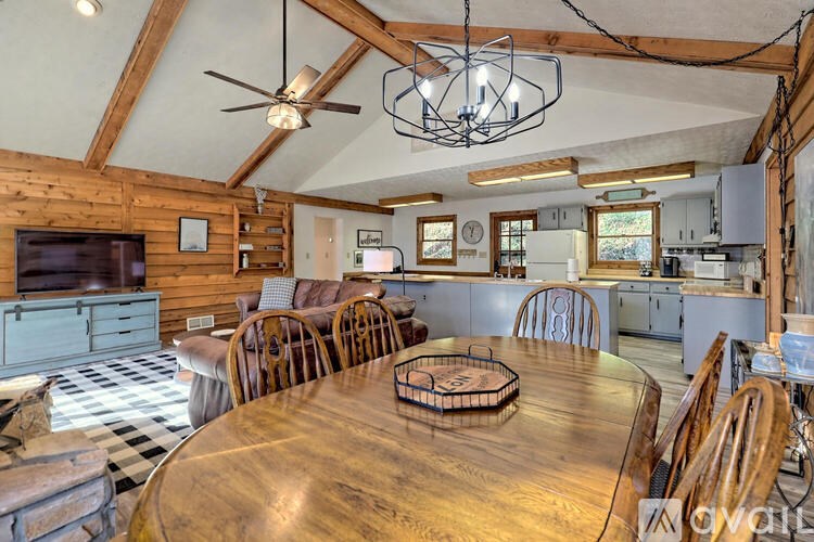A wooden dining table with chairs and a ceiling fan in a room with wooden walls.