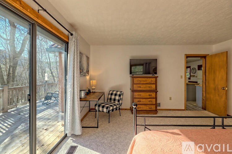 A bedroom with a bed, dresser, and chair in it.